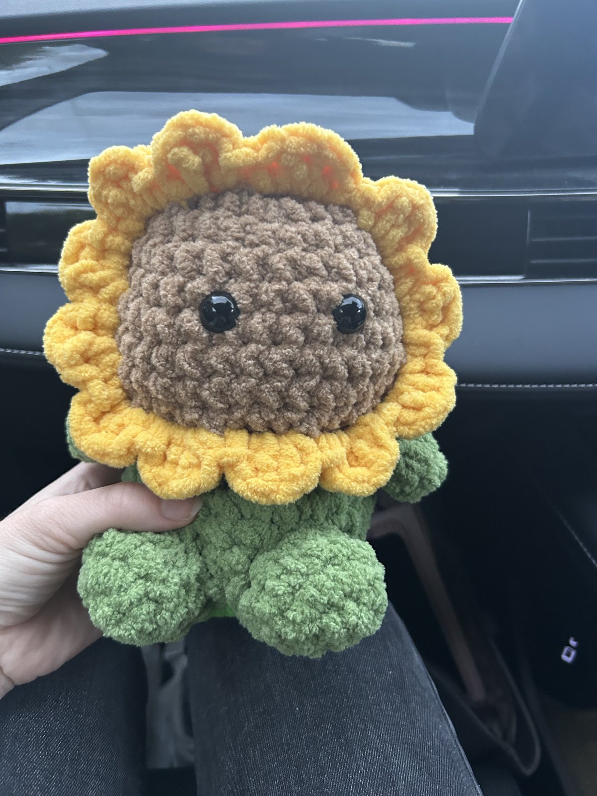 Cheerful crochet sunflower plushie with yellow petals and green leaves